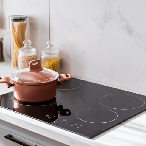 An induction cooktop being used in a modern kitchen to cook food, a home appliance trend for 2025