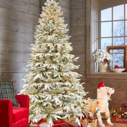 White snow flocked Christmas tree in cottage