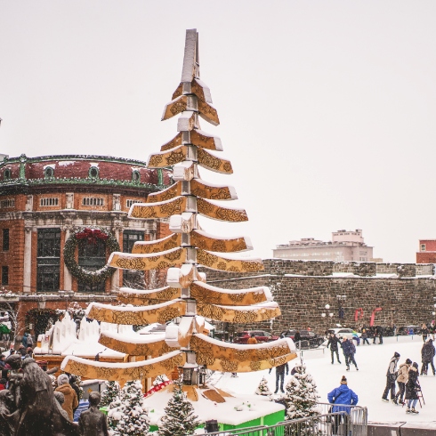 A skating rink, Christmas tree and decorated buildings in Baie-Saint-Paul, Québec during their annual Christmas market.