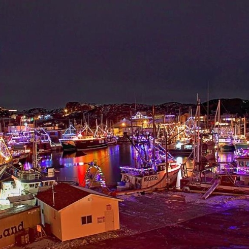 Boats and houses illuminated with colourful lights in Bay Roberts, Newfoundland & Labrador during their Festival of Lights.