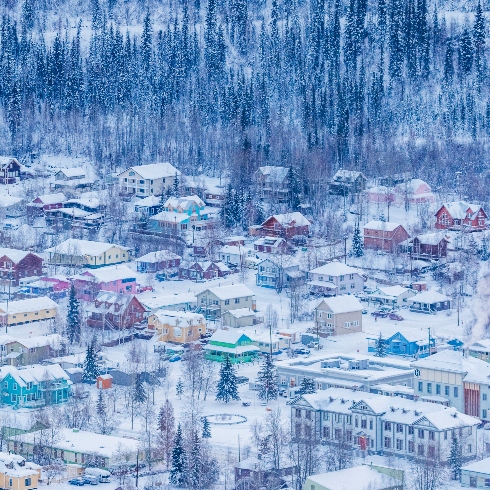 An aerial view of the colourful, snow-covered buildings in Dawson City, Yukon during the winter.