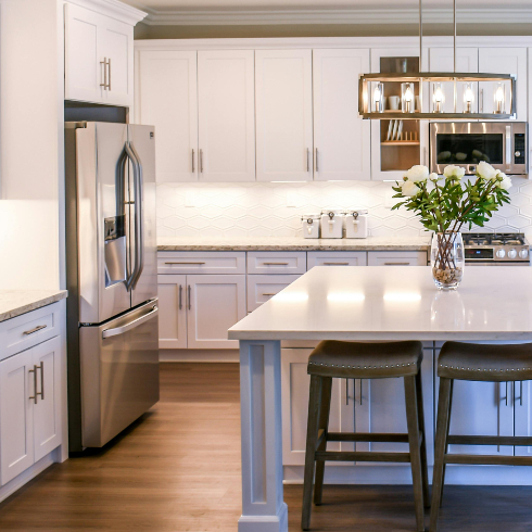 An image of a sparkling clean kitchen with stainless steel fridge