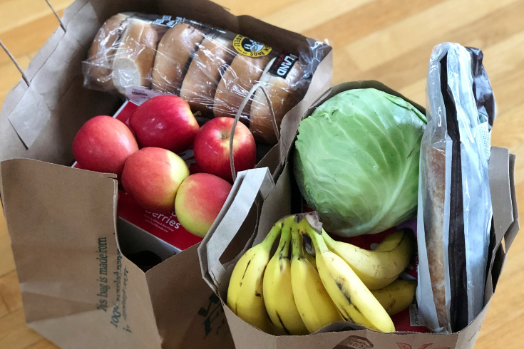 Fresh produce and bread in two paper grocery bags 