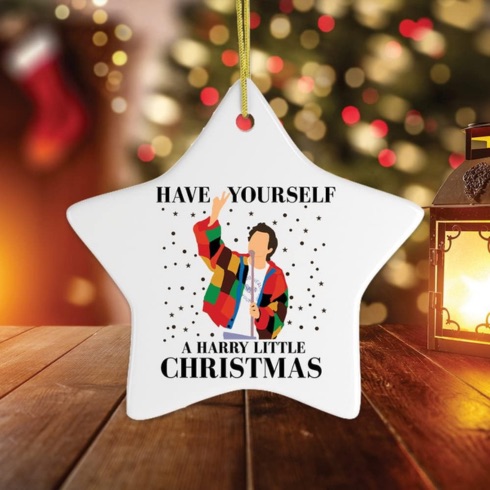 A white star ornament with a cartoon image of Harry Styles, text saying 'Have yourself a harry little Christmas'