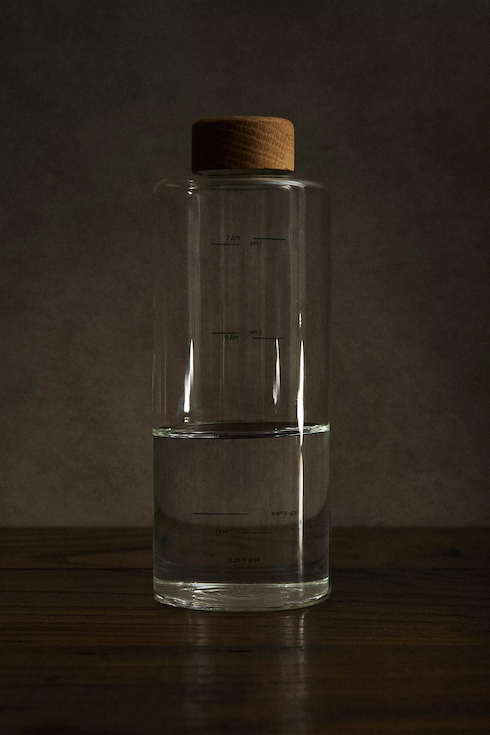 Zara refillable borosilicate glass bottle with oak screw cap sits on a table as part of Home Network Last Minute Gifts
