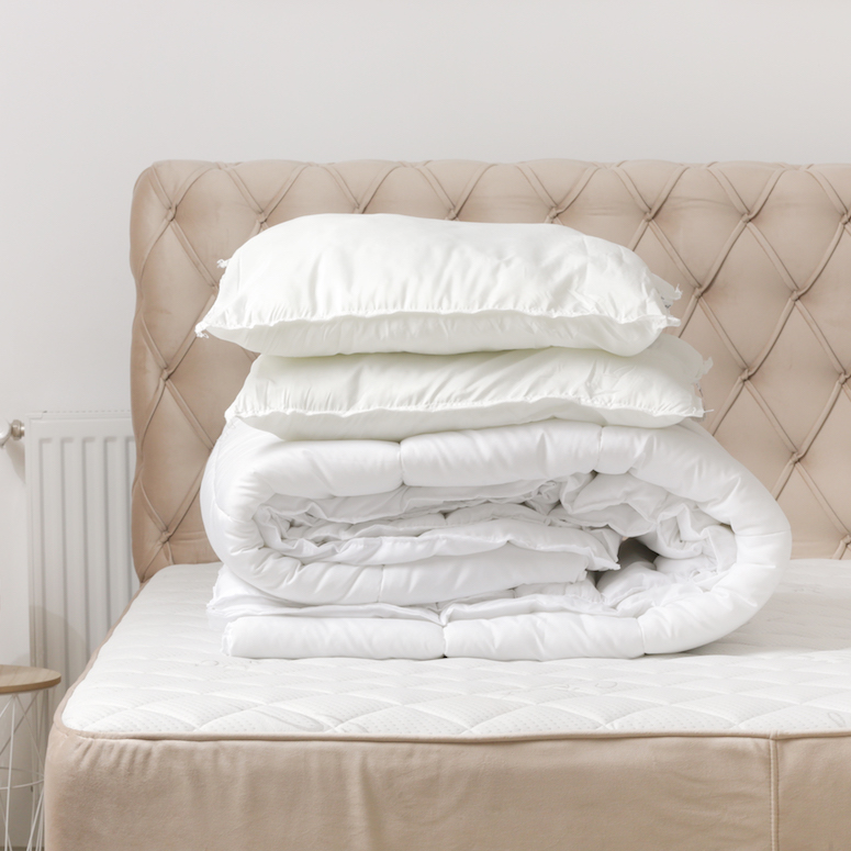 Soft folded duvet and pillows on bed