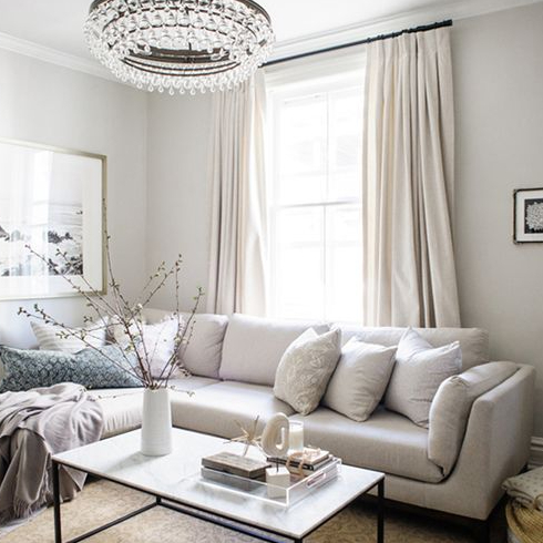 An image of a living room with a statement chandelier