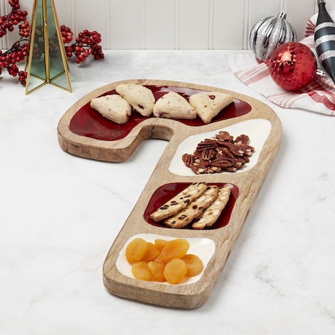 A mix of nuts, dried fried, and baked goods are on a candy cane-shaped serving tray.