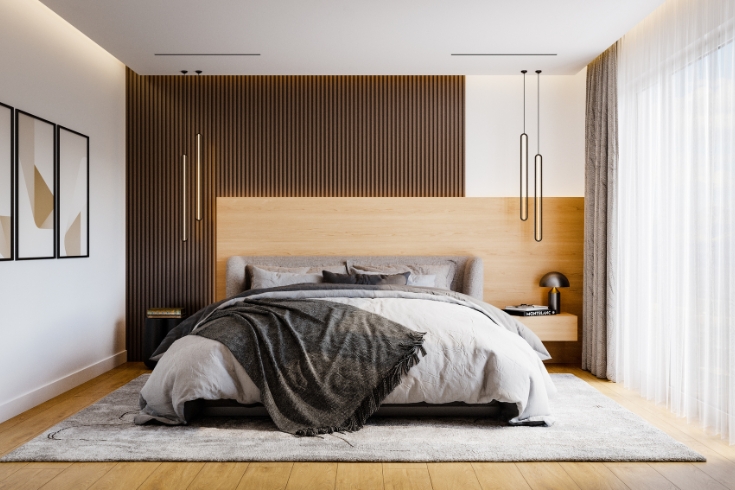 Modern bedroom interior decor featuring neutral coloured bedding and wooden headboard. 