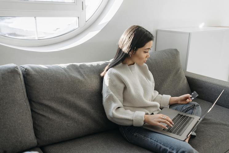 Woman checking credit card with computer