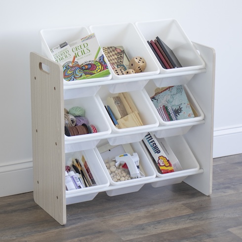 An array of books, toys, and art supplies sit in white bins in a three-tier toy organizer.