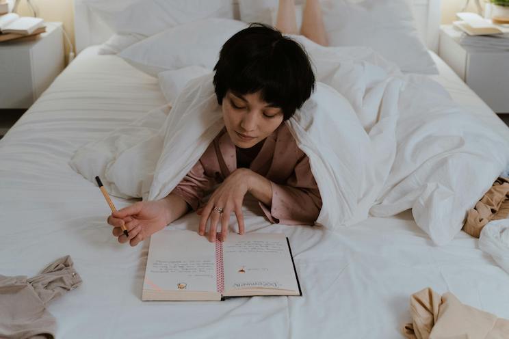 Woman journaling in bed