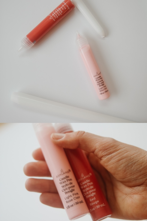 candle wax pens with white tapers on a table