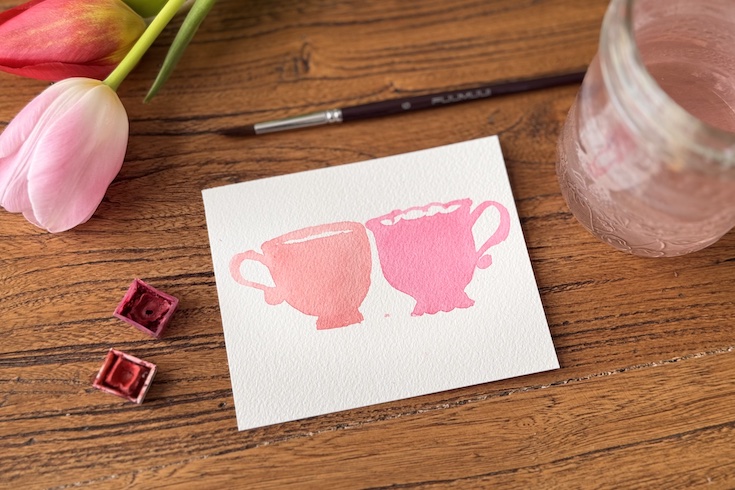 card with base layers of watercolour painted teacups in red and pink
