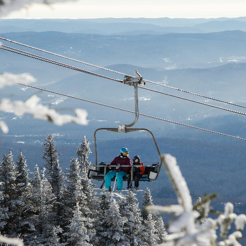 Skiiers on a ski lift at Mont Tremblant Ski Resort in Quebec.