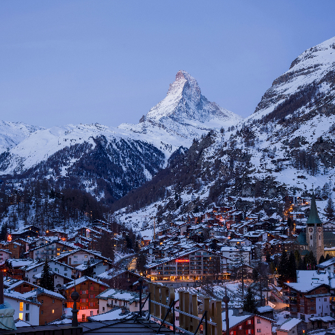 The town of Zermatt in Switzerland at dusk with the Matterhorn in the background.