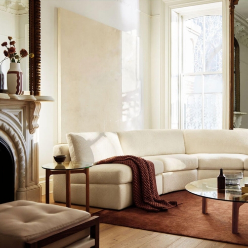 Living room featuring white coach, wooden coffee table with glass top in a sophisticated living room.