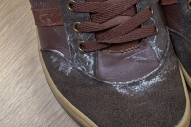 Salt appeared on old suede shoes after a walk in winter.