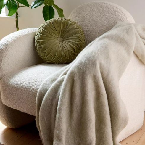 Beige throw blanket on arm of white chair