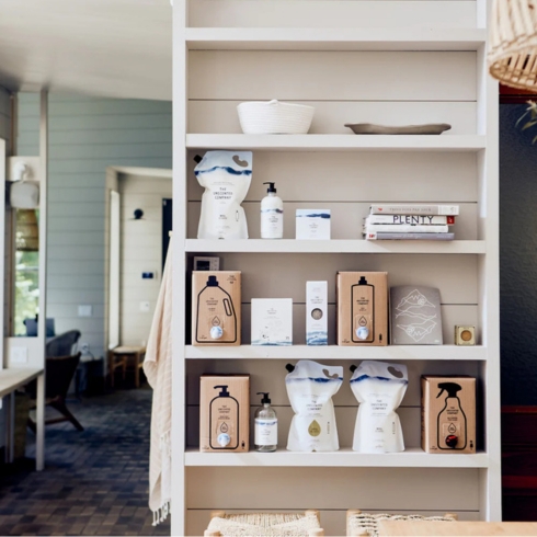 Soap in bottles and refill cartons from unscented company featured on shelves in a rustic room.