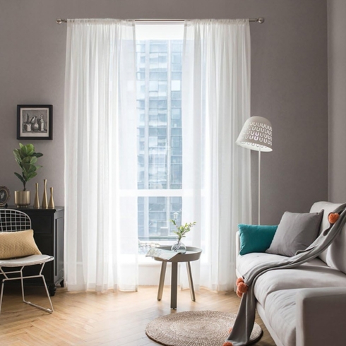 French window with white sheer window curtain in a living room.