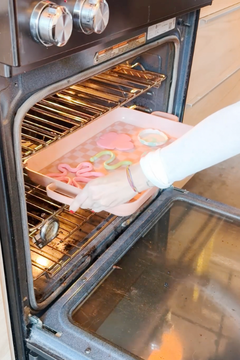 putting in the oven different polymer clay coasters in a tray