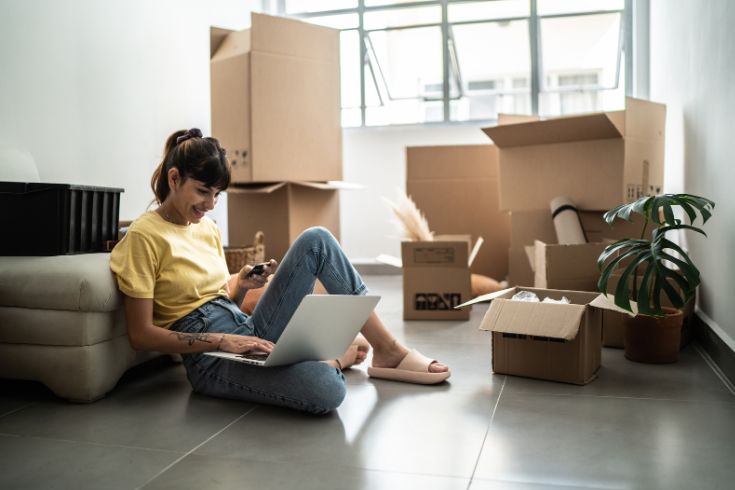 Young woman on her laptop in a new home.