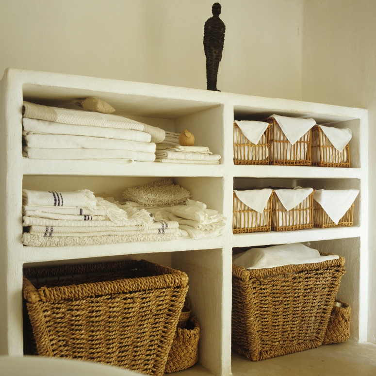 French style baskets and towels in white storage shelves.