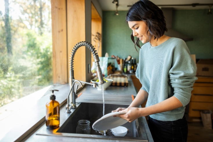 A woman washing dishes in kitchen