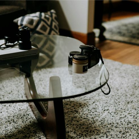 A clear/glass coffee table displayed in a living room.