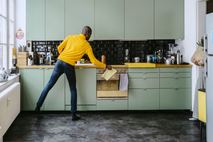 A man doing chores in kitchen at home.