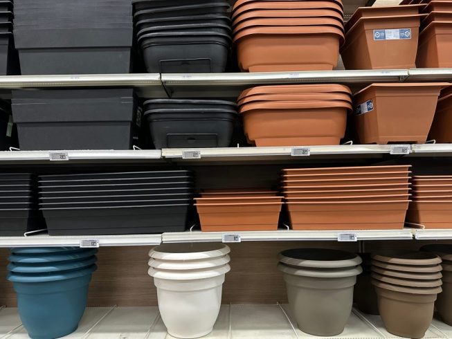 pots and planters of different sizes and colours on a shelf at a store