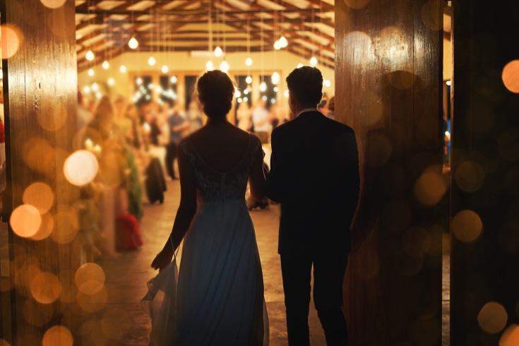 Rearview shot of a young couple arriving hand in hand at their wedding reception,