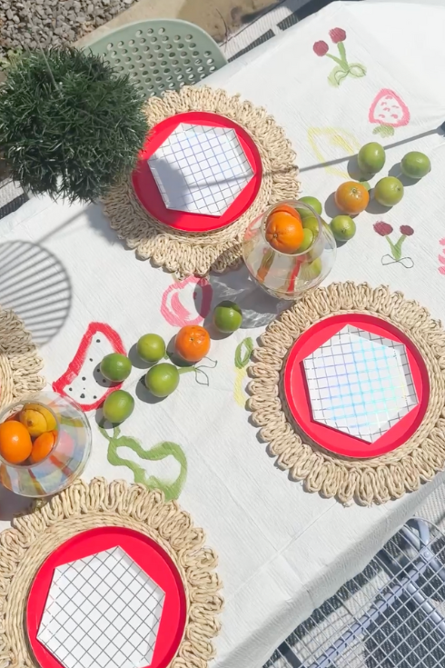 a dreamy picnic table setup with bold colours and plates