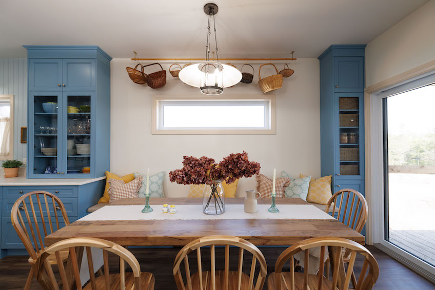 Dining table with bench seating and blue built-in cupboards
