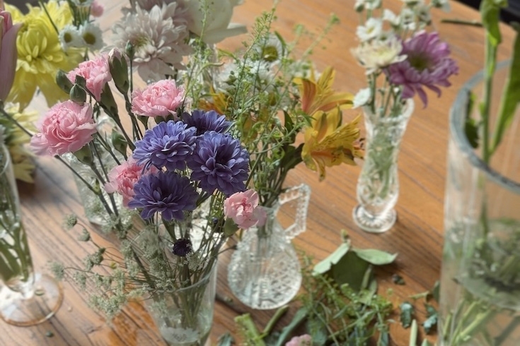 Purple, pink, yellow and white flowers in vases.