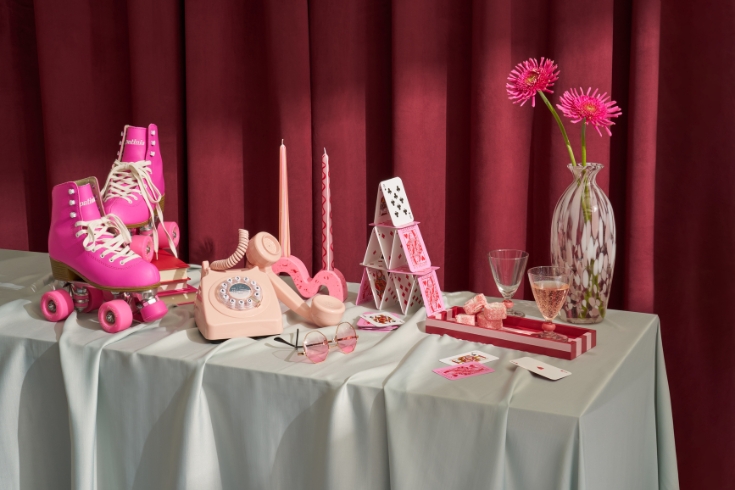 Display of pink roller skates, pink telephone, pokers, pink sunglasses among other pink items.
