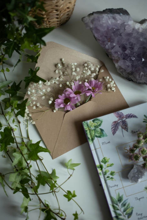 Close-up of Flowers in an Envelope and Crystals on a Table.
