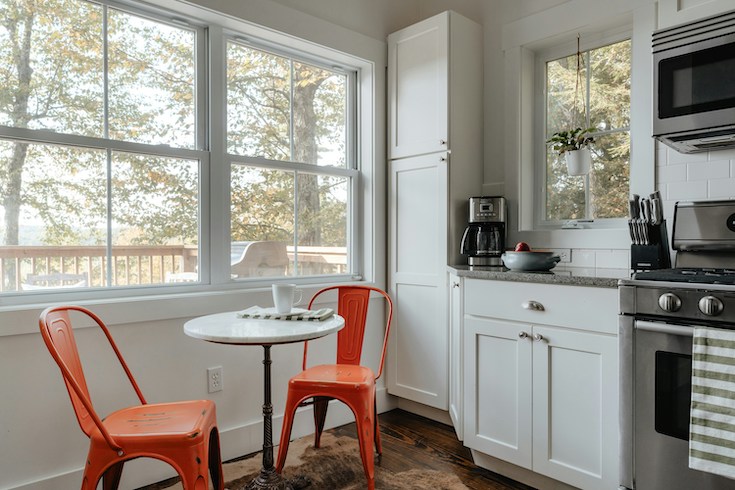 Orange bisto chairs and table in a modern grey and white kitchen