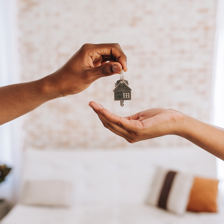 Real estate agent giving a person the keys to new home.