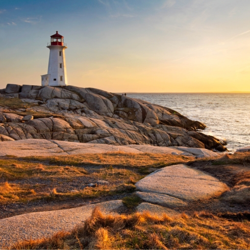 Peggy’s Cove — Halifax, NS Lighthouse on rocky shoreline of Peggy's Cove at sunset.