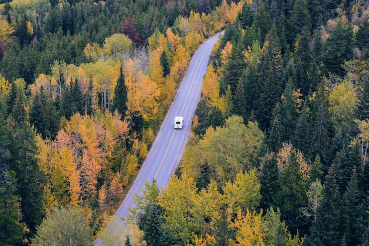 Motorhome driving along a highway surrounded by trees