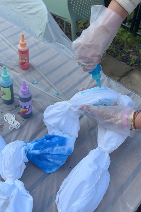 Using blue dye and applying it onto fabric.