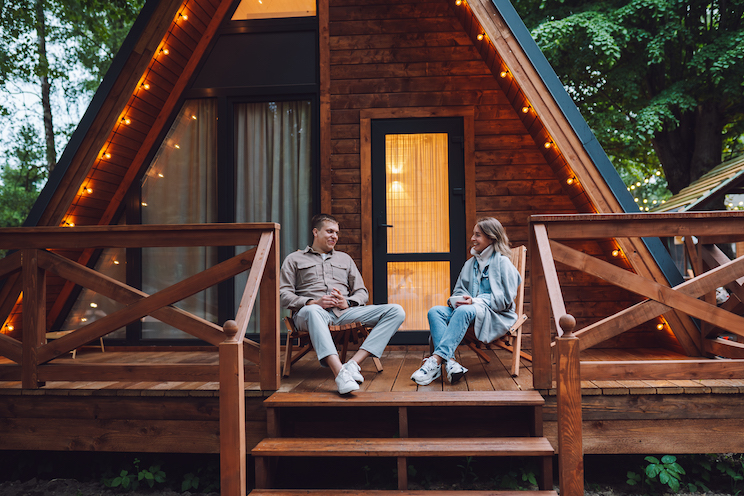Romance in nature. Couple talking on steps of their vacation rental house. Unit and bonding on romantic getaway