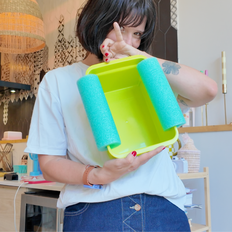 a container with two pool noodles on the side to use as a floating cooler