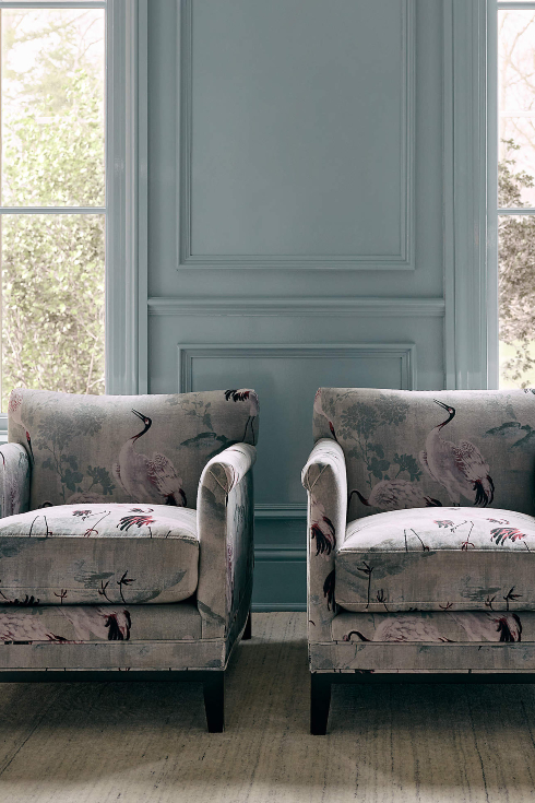 A blue room with bird print chairs