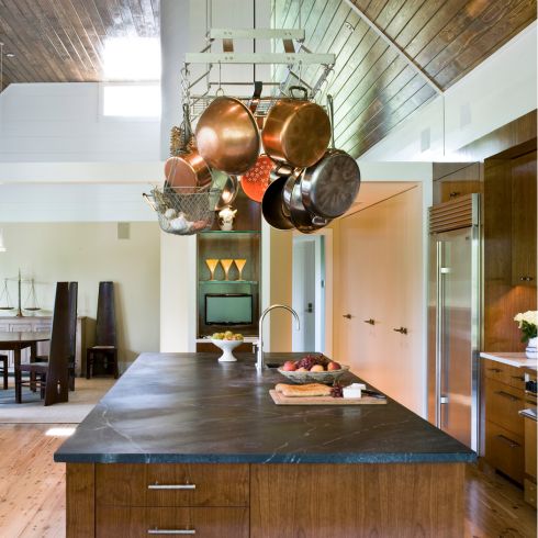 Introduce a Hanging Pot Rack A large modern style kitchen, with plenty of natural light streaming through the windows.