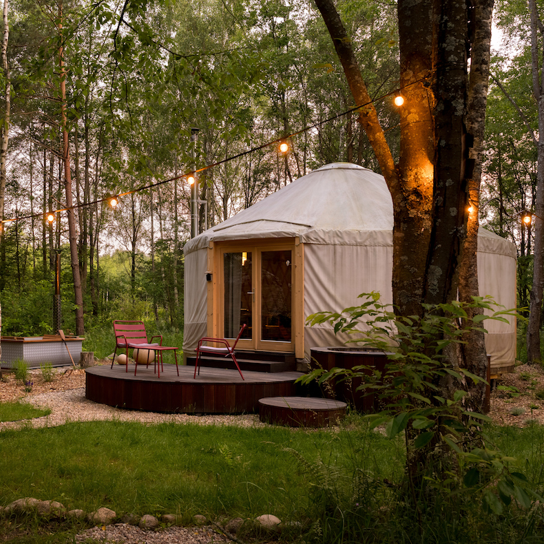 Beautiful yurt tent for glamping style holiday with charming decorations in green forest