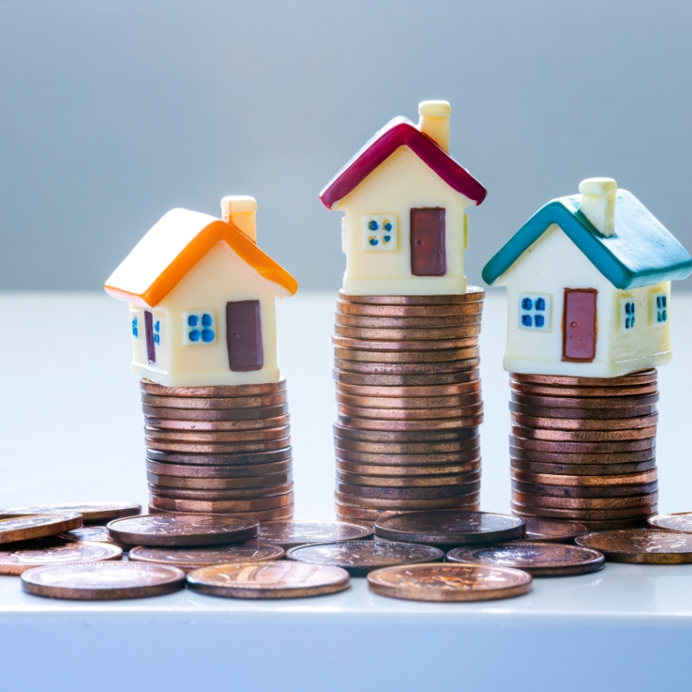 Houses on top of stacks of coins.