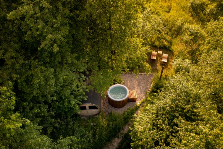 Top view of hot tub and relax area on glamping campsite in forest.